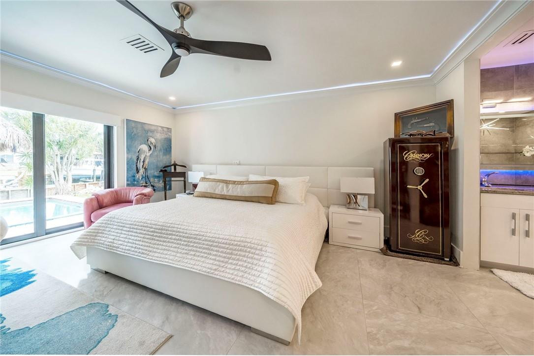 730 Northeast 69th Street Boca Raton, FL 33487 - Photo 13 of 32 a bedroom with a bed and a large mirror