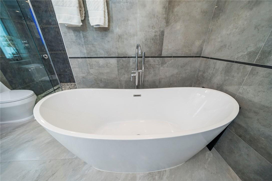 730 Northeast 69th Street Boca Raton, FL 33487 - Photo 18 of 32 a white bath tub sitting in a bathroom