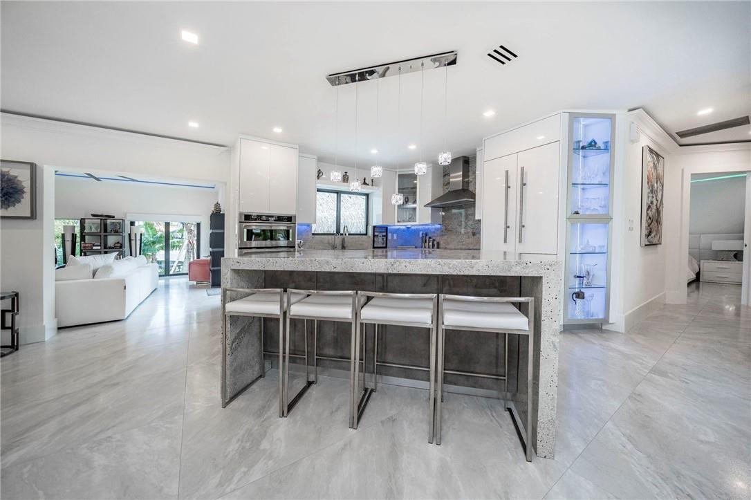 730 Northeast 69th Street Boca Raton, FL 33487 - Photo 2 of 32 a dining area with stainless steel appliances kitchen island granite countertop furniture and a living room