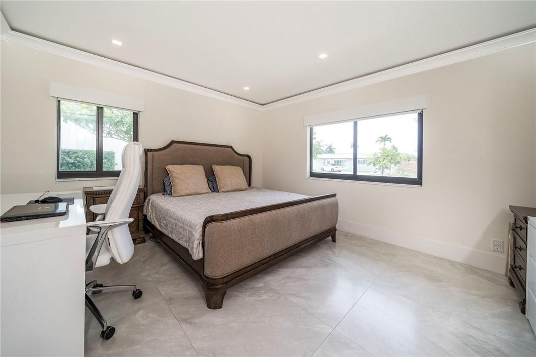 730 Northeast 69th Street Boca Raton, FL 33487 - Photo 23 of 32 a bedroom with a bed lamp closet and window