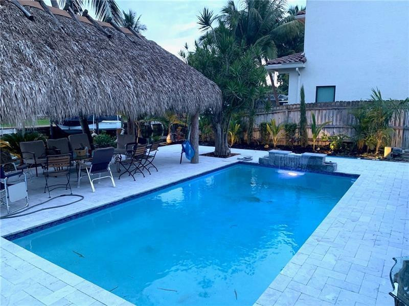 730 Northeast 69th Street Boca Raton, FL 33487 - Photo 3 of 32 a view of a swimming pool with outdoor seating and plants