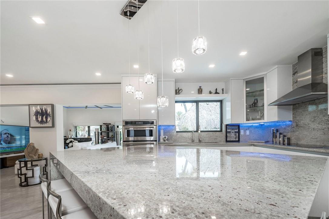 730 Northeast 69th Street Boca Raton, FL 33487 - Photo 7 of 32 a kitchen with stainless steel appliances granite countertop a sink a stove and a cabinets