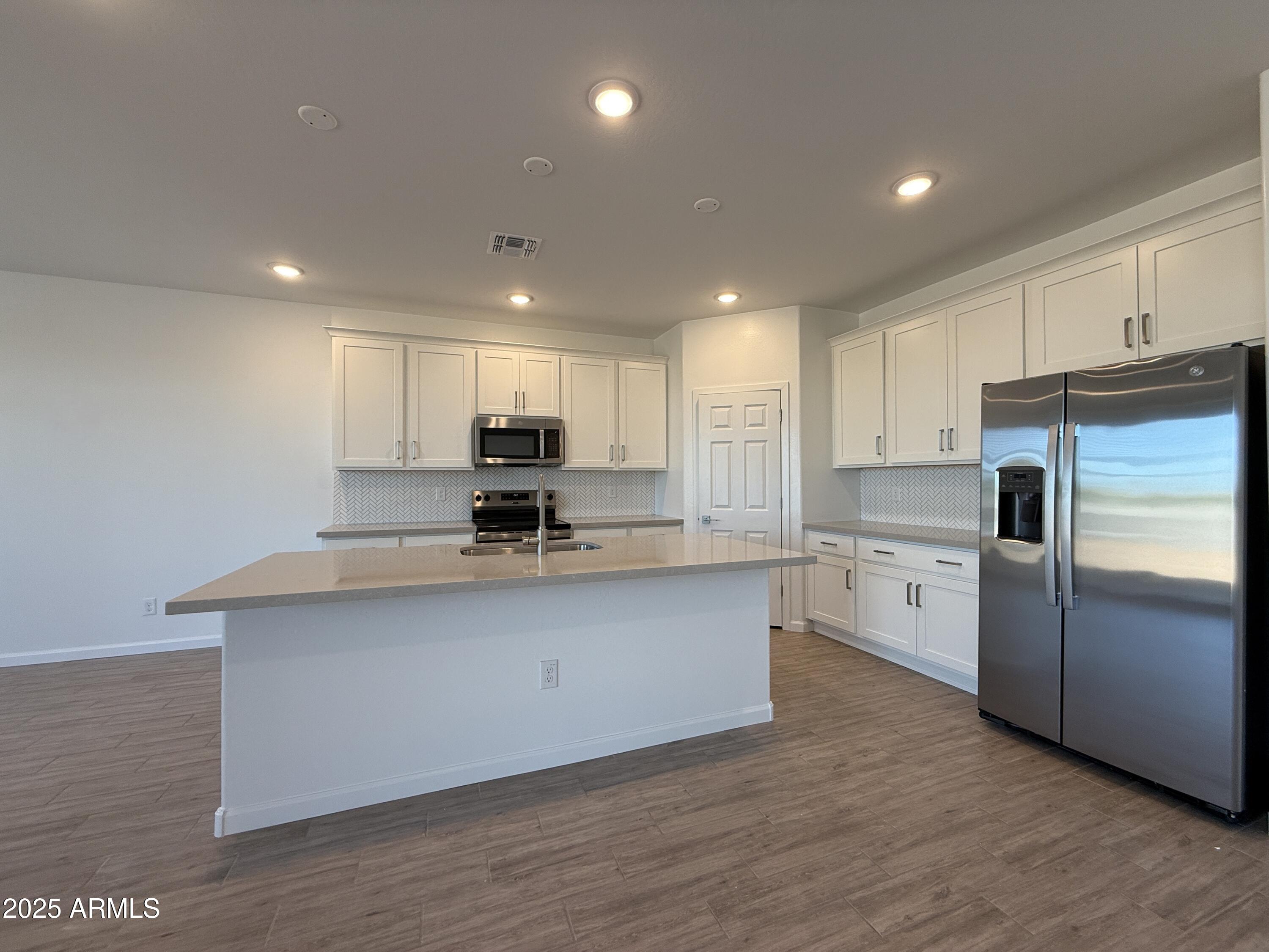 9628 West Tamarisk Avenue Tolleson, AZ 85353 - Photo 14 of 37 a kitchen with stainless steel appliances granite countertop a sink refrigerator and microwave