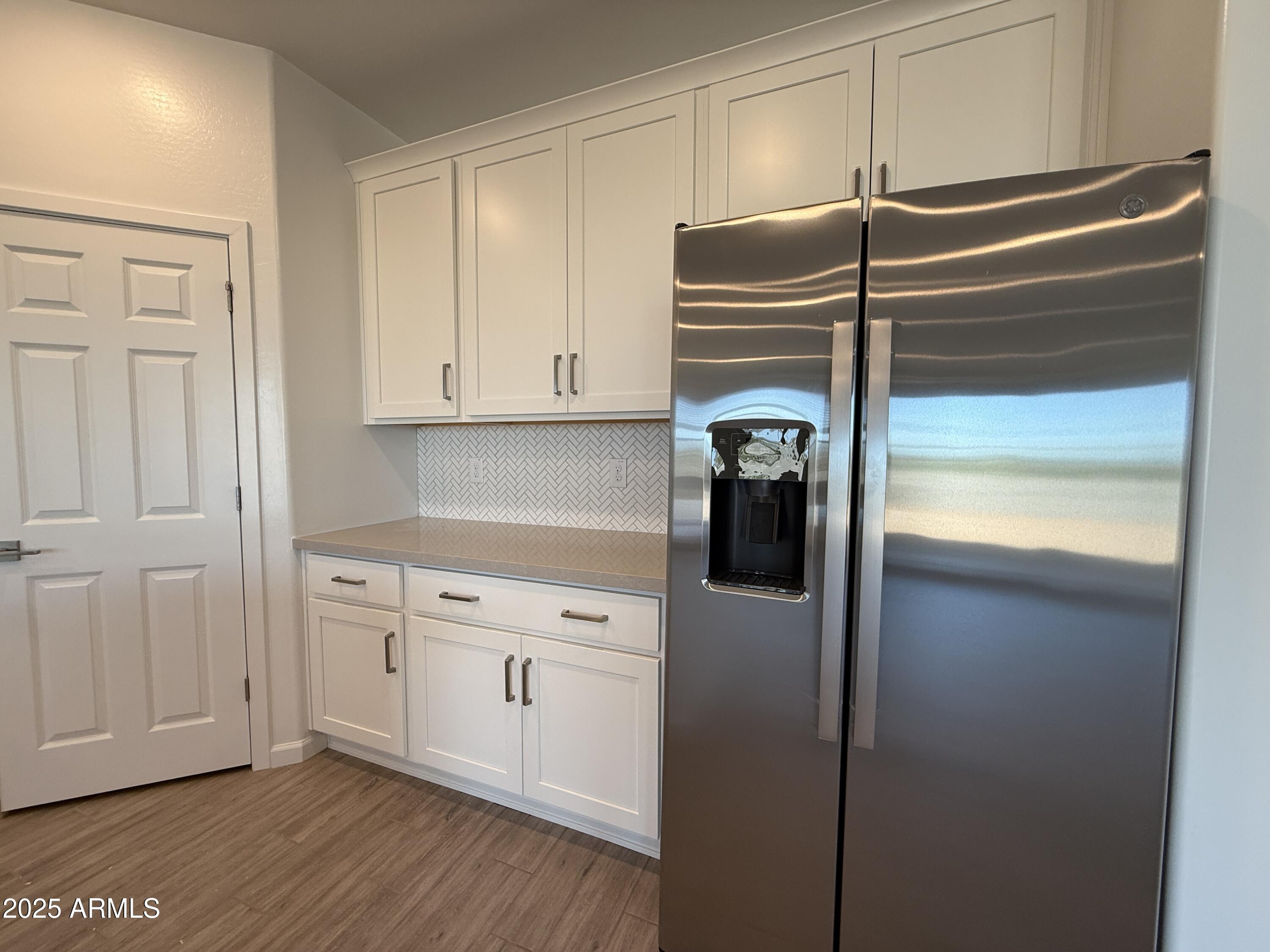 9628 West Tamarisk Avenue Tolleson, AZ 85353 - Photo 16 of 37 a kitchen with a refrigerator and cabinets