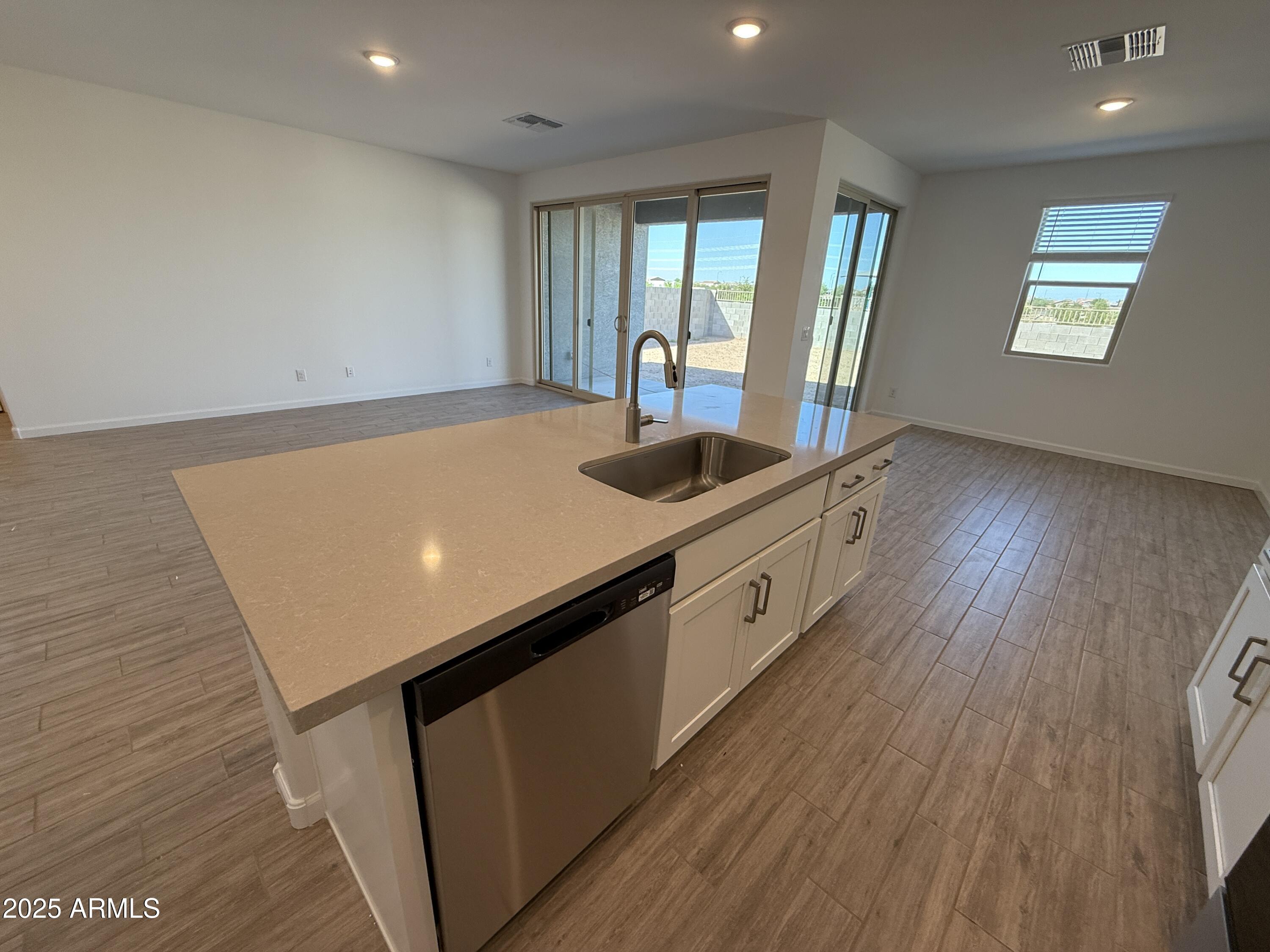 9628 West Tamarisk Avenue Tolleson, AZ 85353 - Photo 17 of 37 a kitchen with stainless steel appliances granite countertop a sink and wooden floor