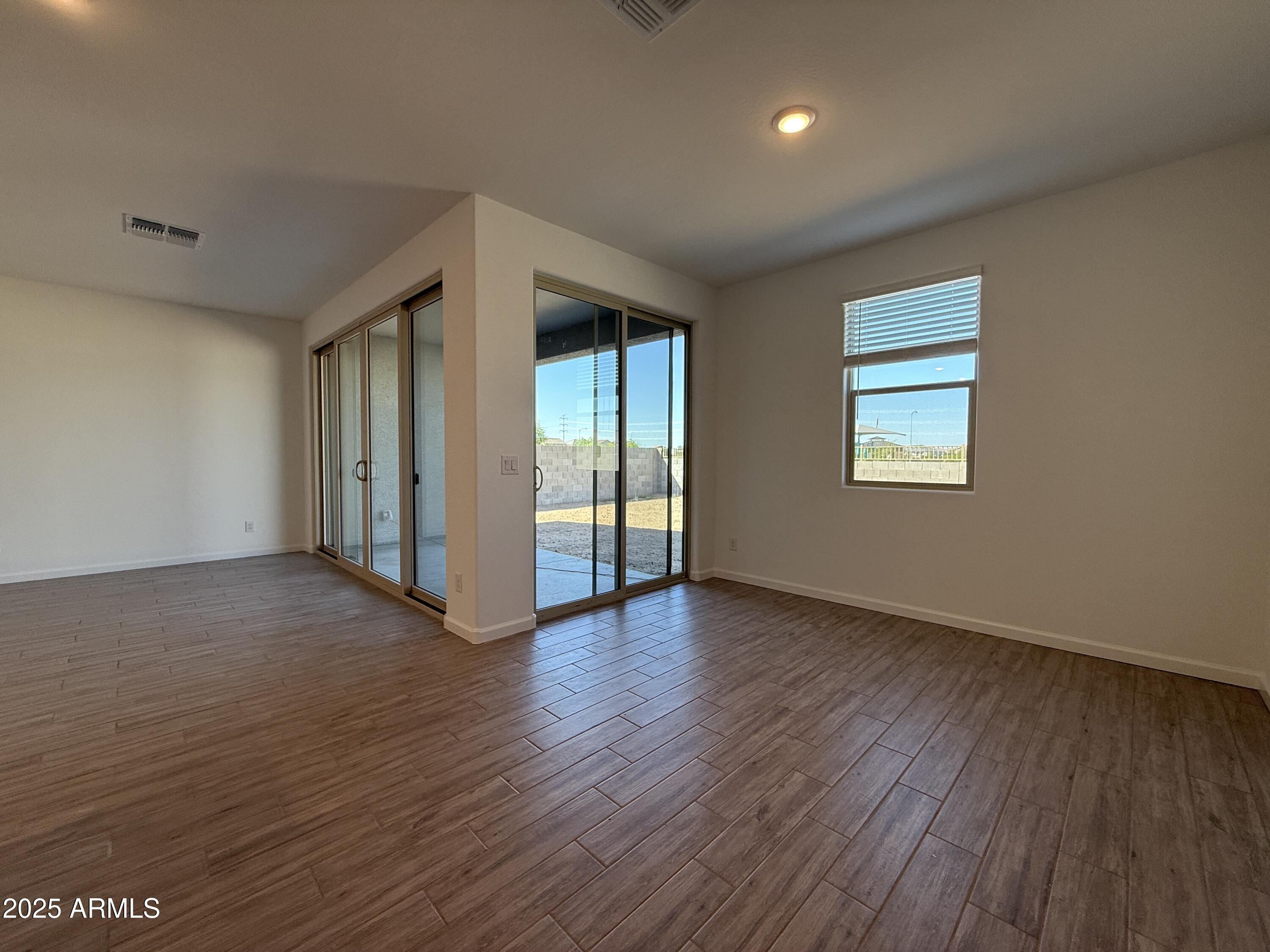 9628 West Tamarisk Avenue Tolleson, AZ 85353 - Photo 18 of 37 an empty room with wooden floor and windows