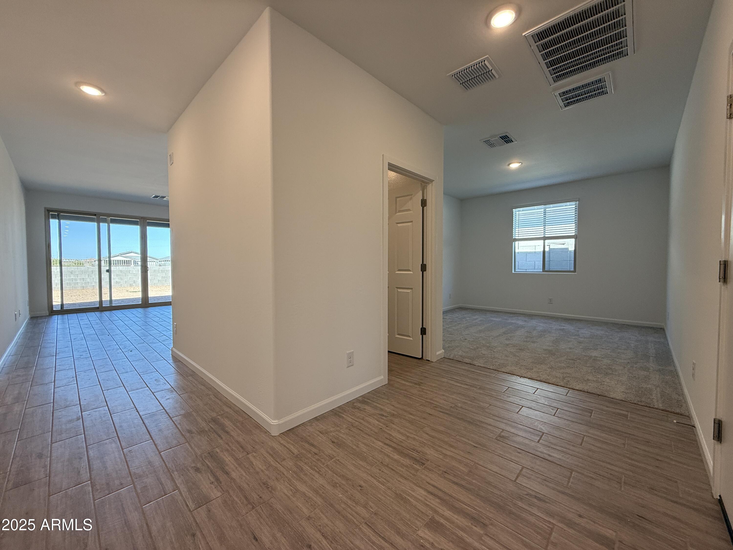 9628 West Tamarisk Avenue Tolleson, AZ 85353 - Photo 9 of 37 an empty room with wooden floor and windows