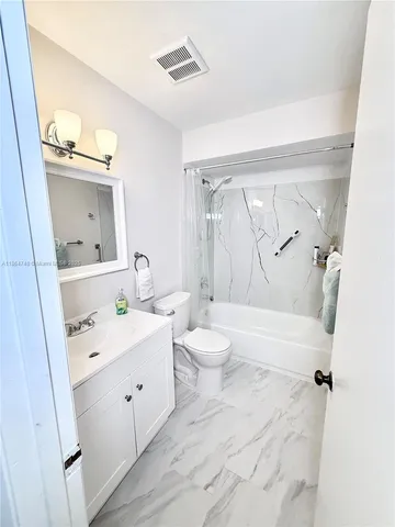 a bathroom with a double vanity sink toilet and shower