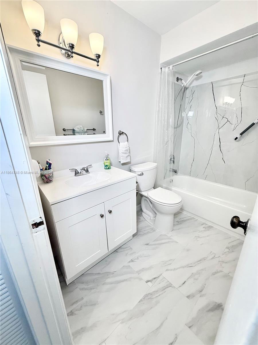 11028 Southwest 132nd Place, Unit 244 Miami, FL 33186 - Photo 15 of 25 a bathroom with a sink toilet and mirror