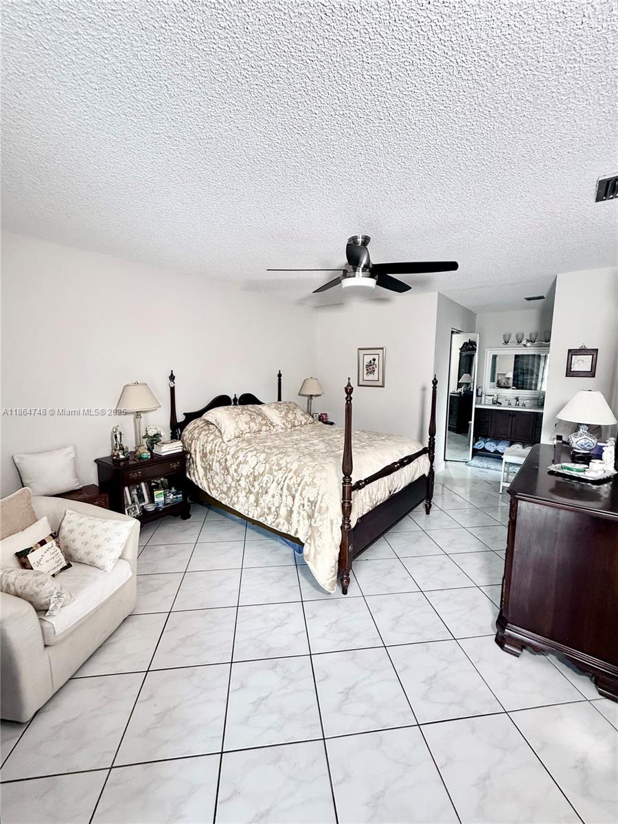 11028 Southwest 132nd Place, Unit 244 Miami, FL 33186 - Photo 16 of 25 a bedroom with furniture and a couch