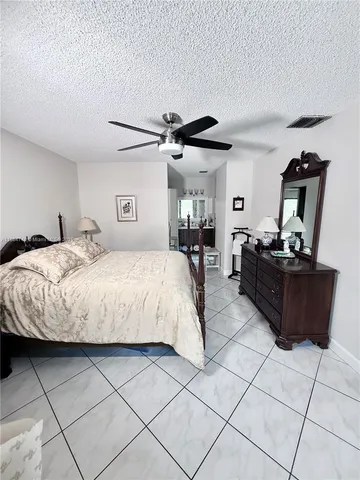 a bedroom with a bed and a ceiling fan