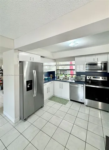a kitchen with stainless steel appliances a refrigerator sink and microwave