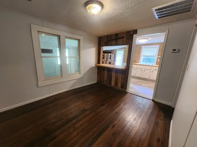a kitchen with granite countertop stainless steel appliances a sink window and cabinets
