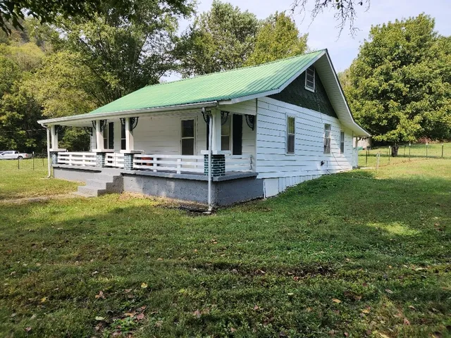 a view of a green field with trees in the background