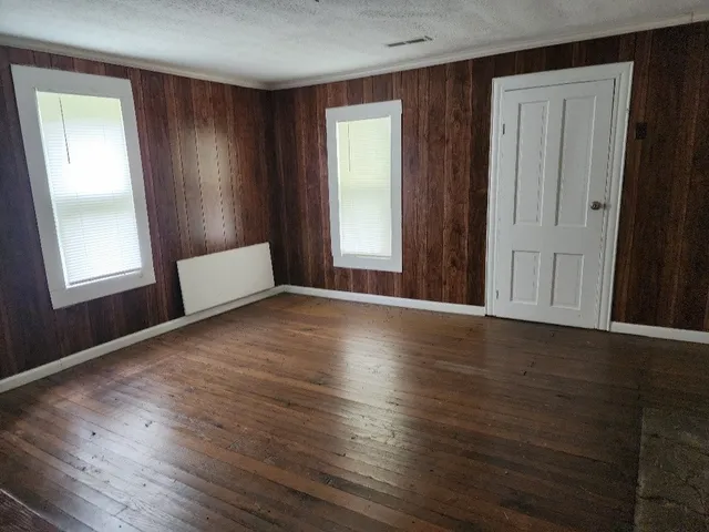 an empty room with wooden floor and a window