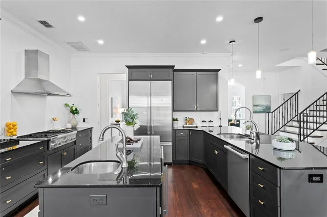 a kitchen with stainless steel appliances granite countertop a sink and a refrigerator