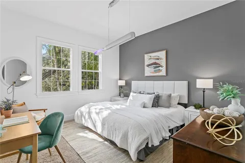 a spacious bedroom with a bed a couch and potted plant with the outer view