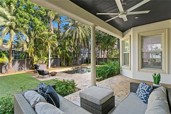 a view of a patio with couches and table and chairs with plants