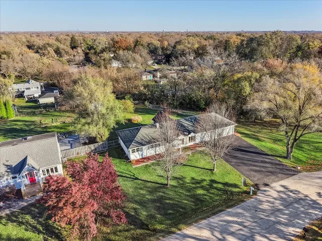 an aerial view of a house with a garden and lake view