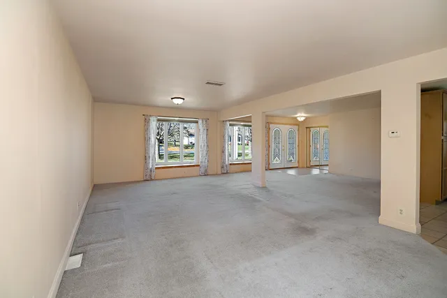 a view of an empty room with a window and fireplace