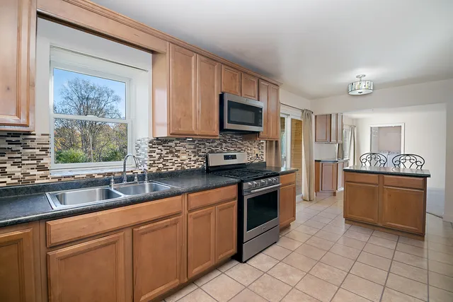 a kitchen with stainless steel appliances granite countertop a stove sink and microwave