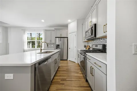 a large kitchen with stainless steel appliances granite countertop a lot of counter space and a sink