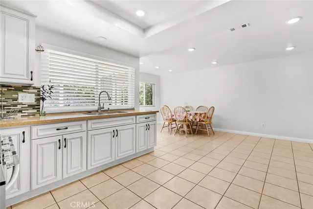 a kitchen with white cabinets a sink and appliances