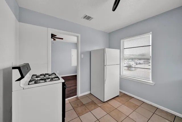 a kitchen that has a refrigerator and a stove in it