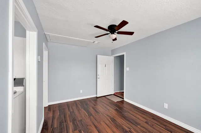 a view of room with wooden floor and ceiling fan