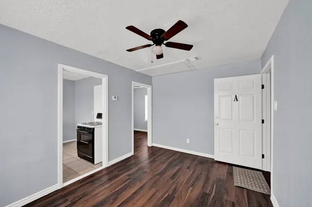 a view of cabinets with wooden floor and ceiling fan