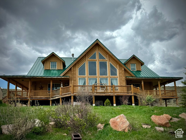 Back of property featuring metal roof, a standing seam roof, and a deck