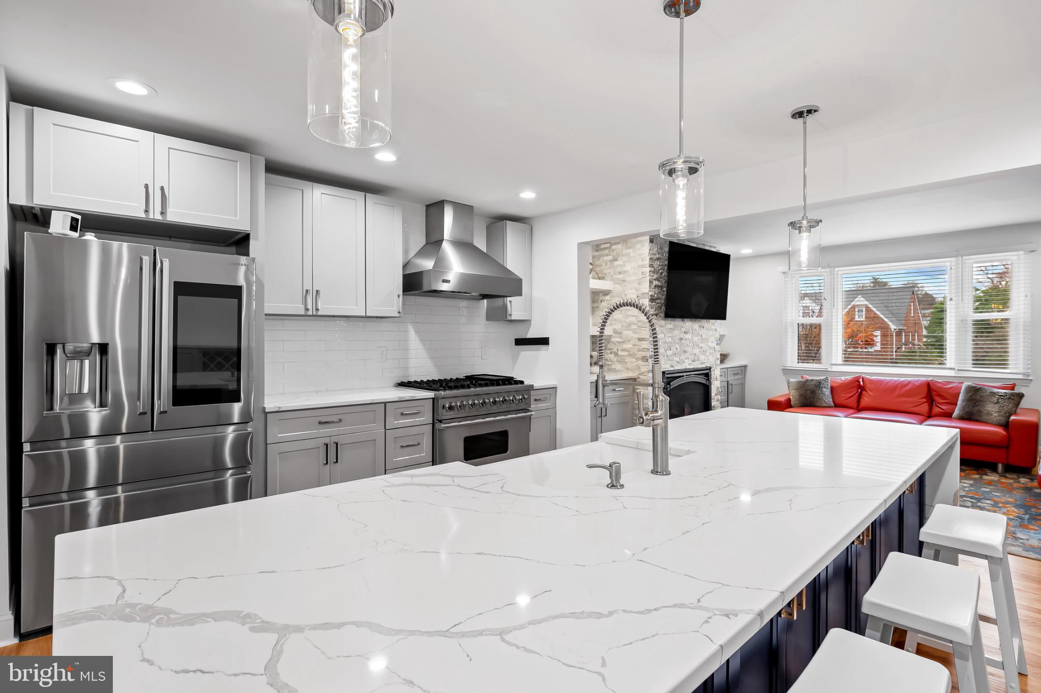 312 Waveland Road Catonsville, MD 21228 - Photo 9 of 40 a kitchen with stainless steel appliances kitchen island granite countertop a stove a sink a refrigerator a center island with wooden floor and cabinets