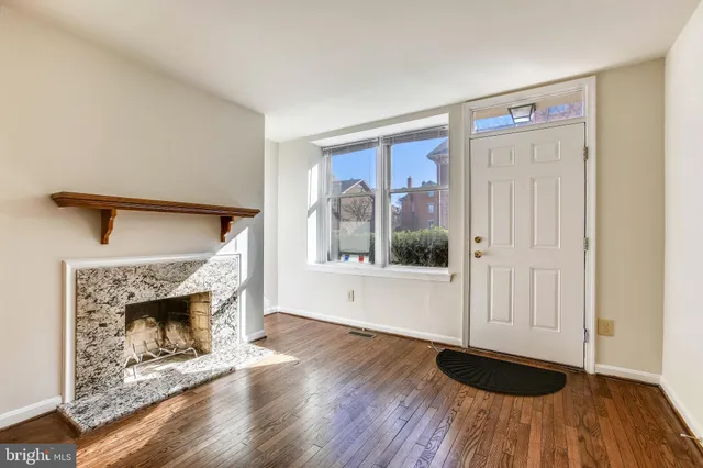 a view of a livingroom with wooden floor and a fireplace
