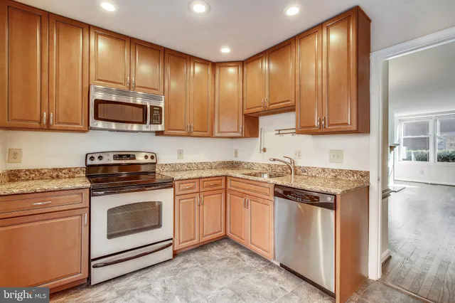 a kitchen with granite countertop wooden cabinets and stainless steel appliances