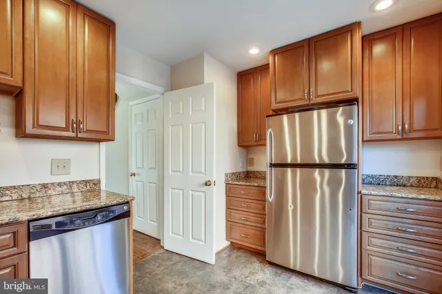 a kitchen with stainless steel appliances granite countertop a refrigerator a microwave and cabinets