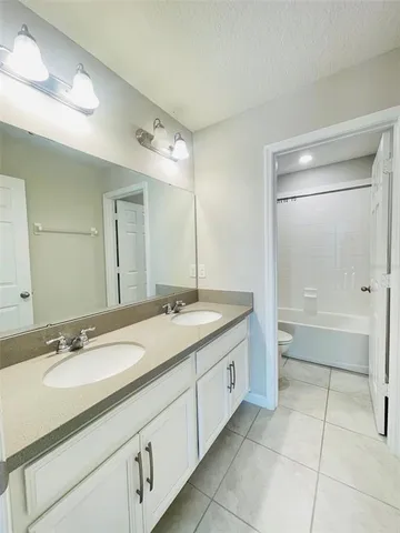 a bathroom with a granite countertop sink mirror and a bathtub