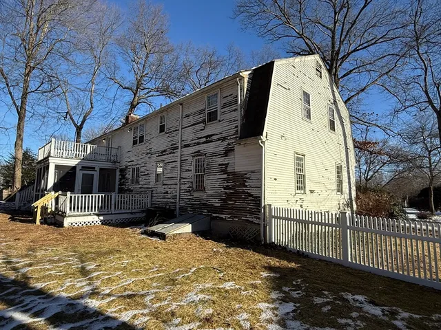 a view of a house with a wooden fence