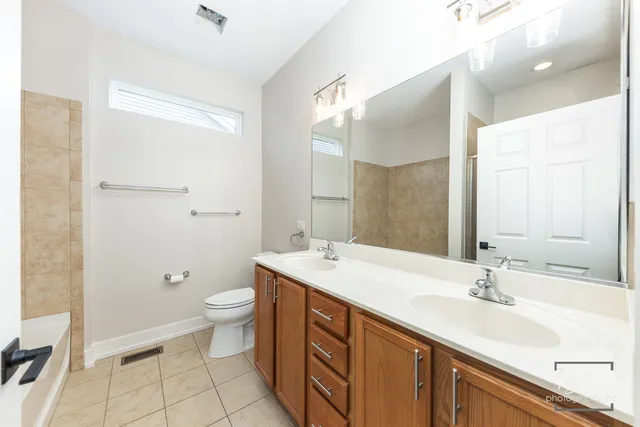 a bathroom with a sink a toilet a large mirror and shower