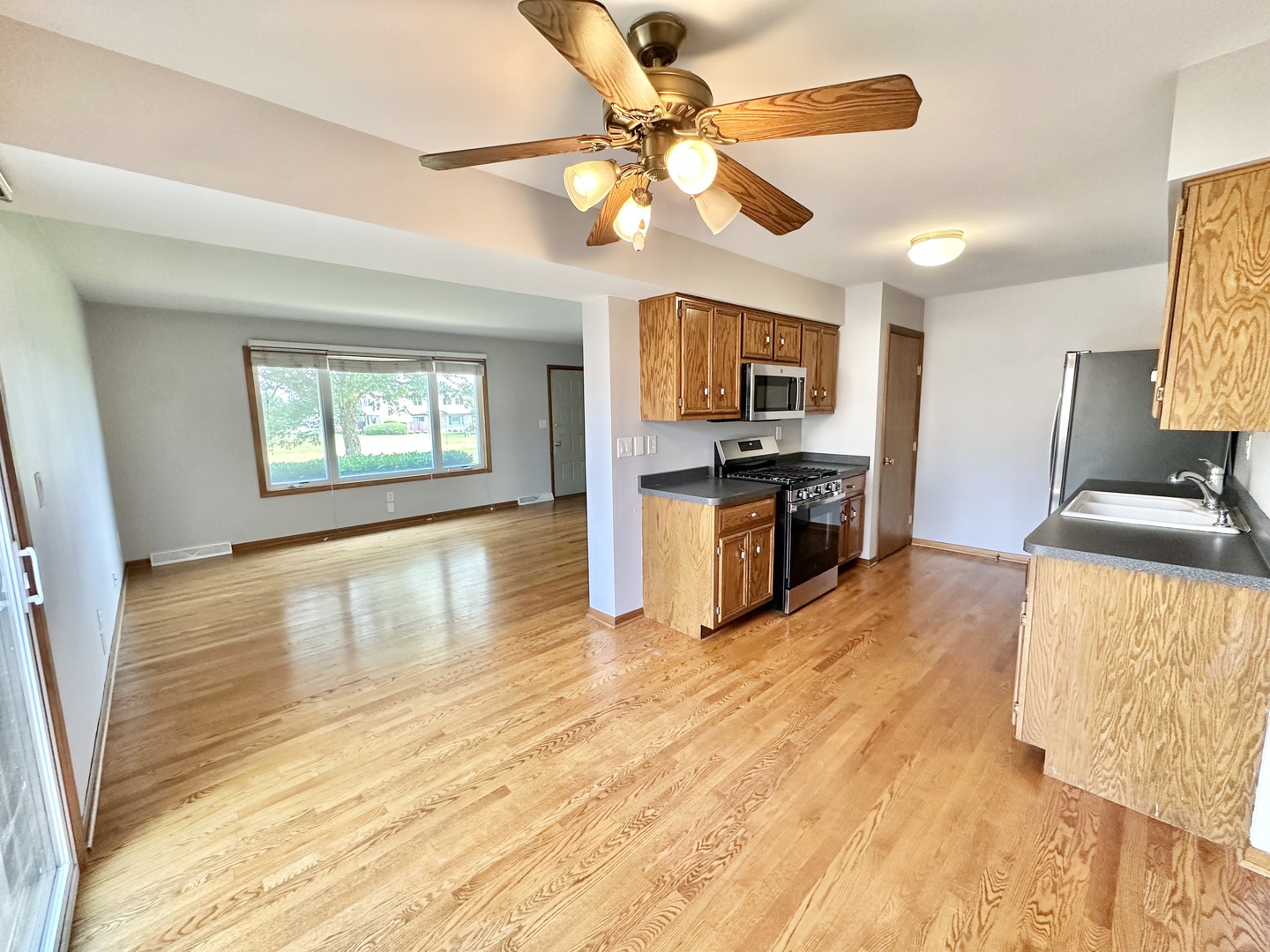 762 Lake Road New Lenox, IL 60451 - Photo 14 of 24 a view of a kitchen with a stove cabinets a ceiling fan and wooden floor
