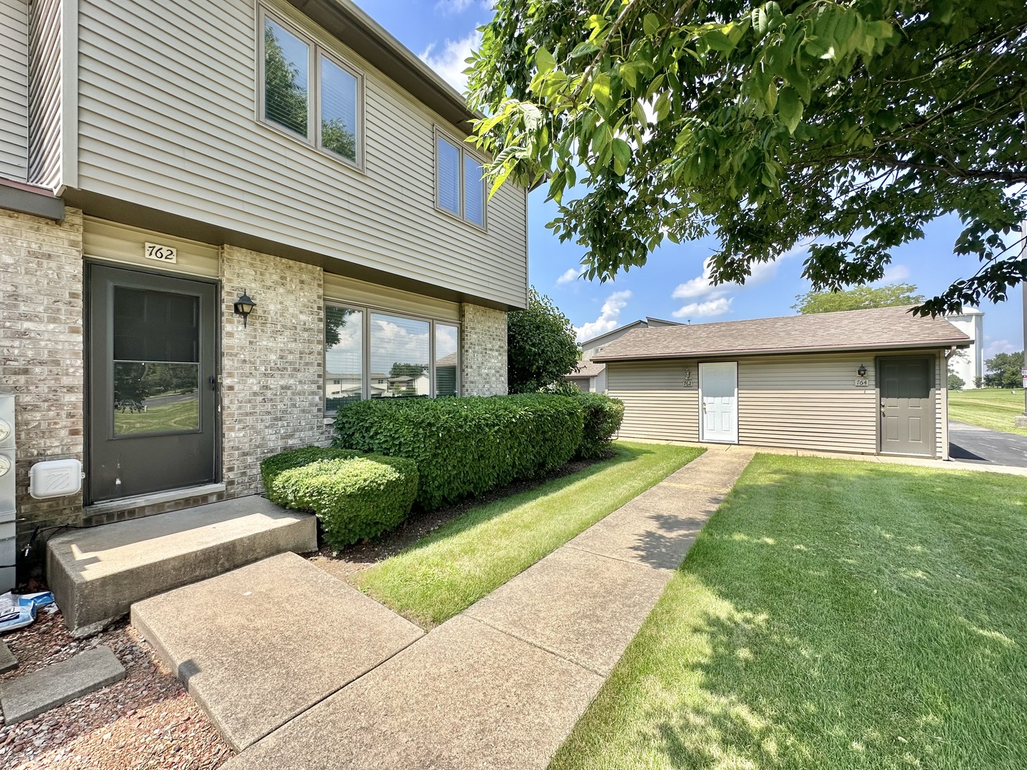 762 Lake Road New Lenox, IL 60451 - Photo 2 of 24 a front view of a house with garden