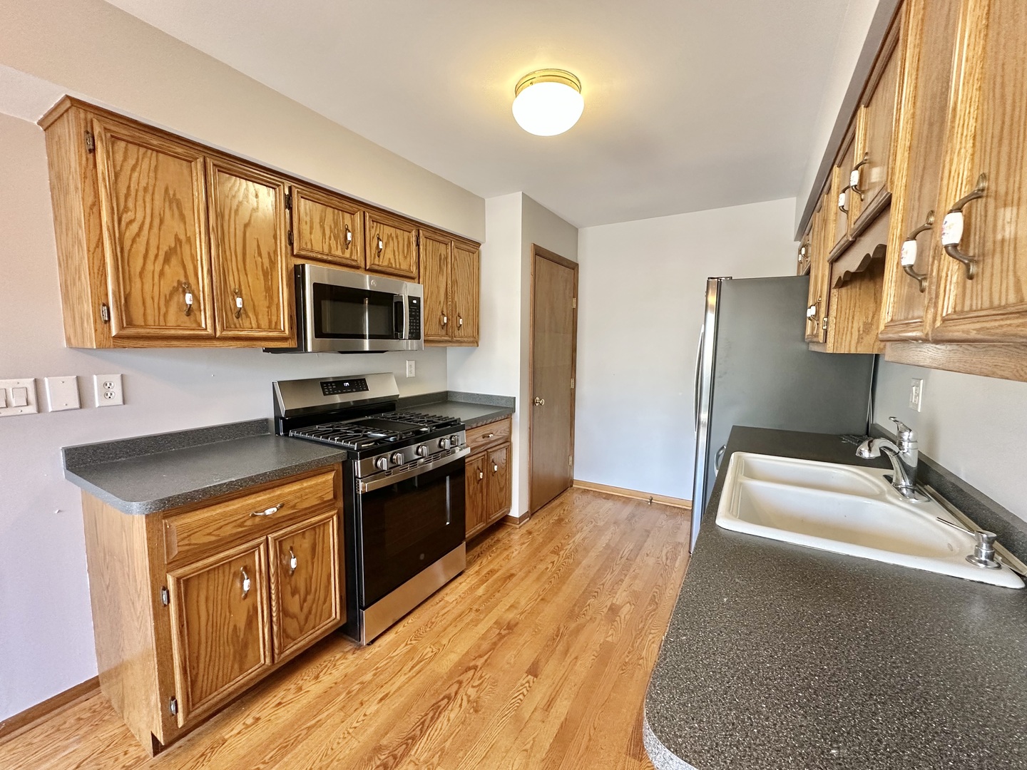 762 Lake Road New Lenox, IL 60451 - Photo 4 of 24 a kitchen with stainless steel appliances granite countertop a stove a sink and a microwave