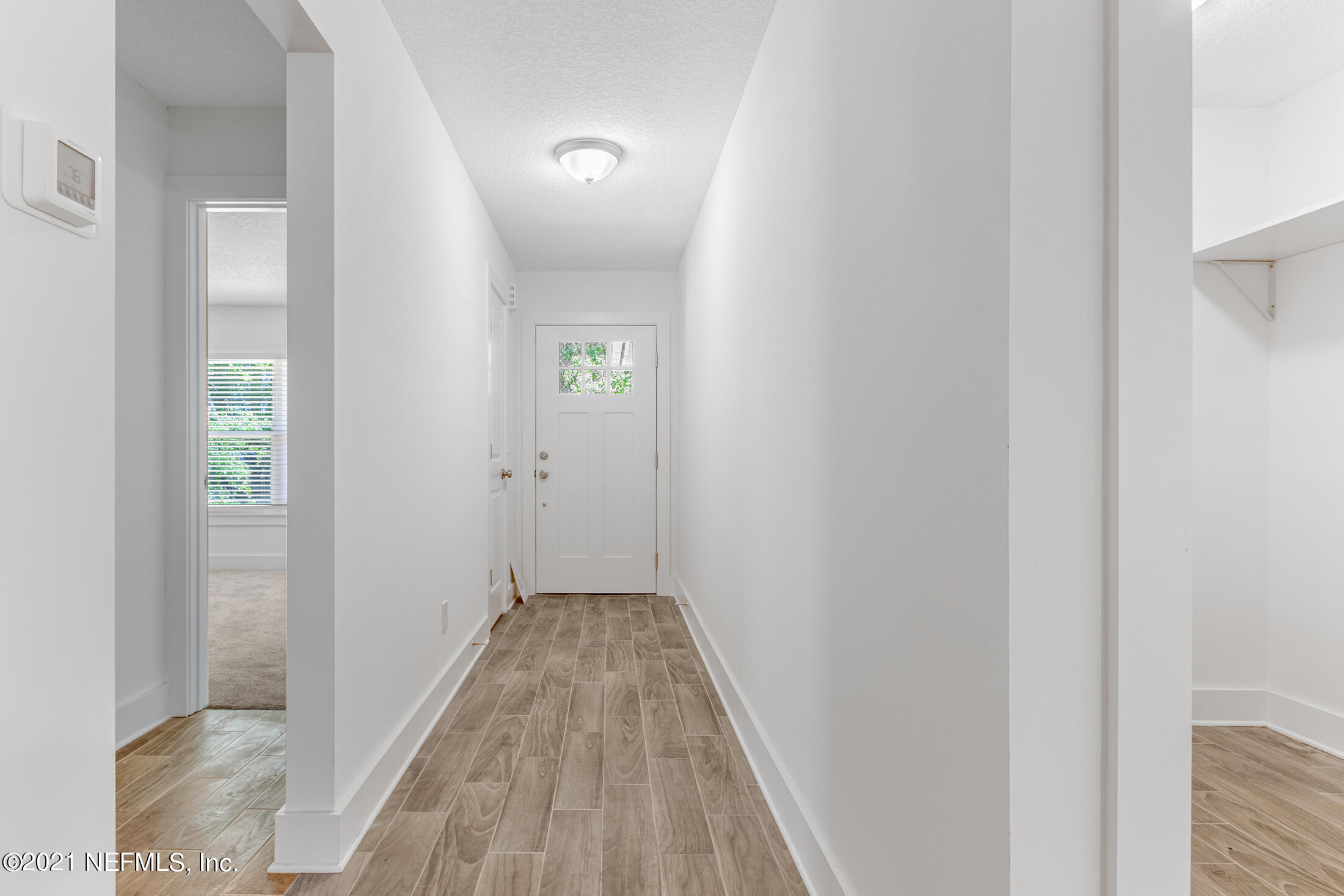 528 Meteor Street Jacksonville, FL 32205 - Photo 6 of 34 a view of a hallway with wooden floor and a bathroom