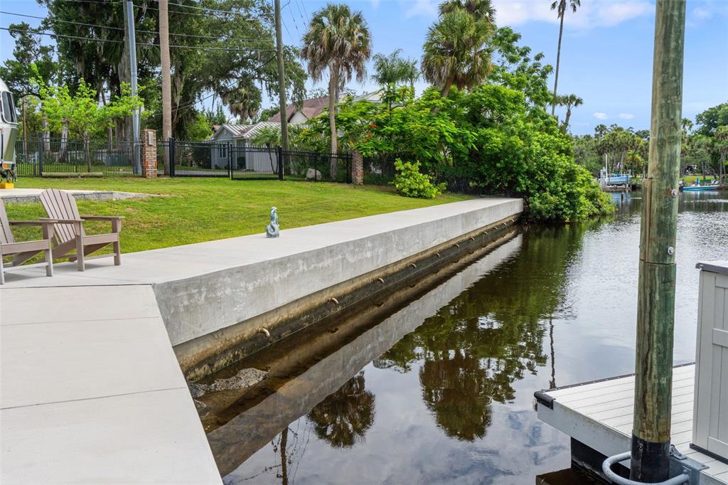 6936 River Road New Port Richey, FL 34652 - Photo 78 of 93 a view of a lake with a bench and trees around