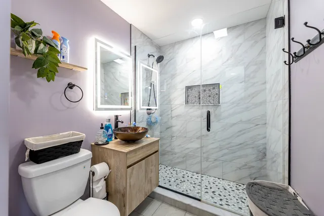 a bathroom with a granite countertop sink a mirror a vanity and a shower