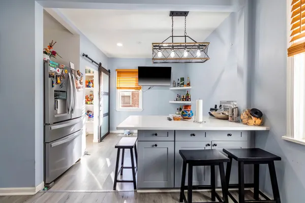 a kitchen with stainless steel appliances a table chairs and chandelier