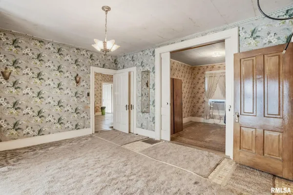 a view of a hallway with a chandelier and living room