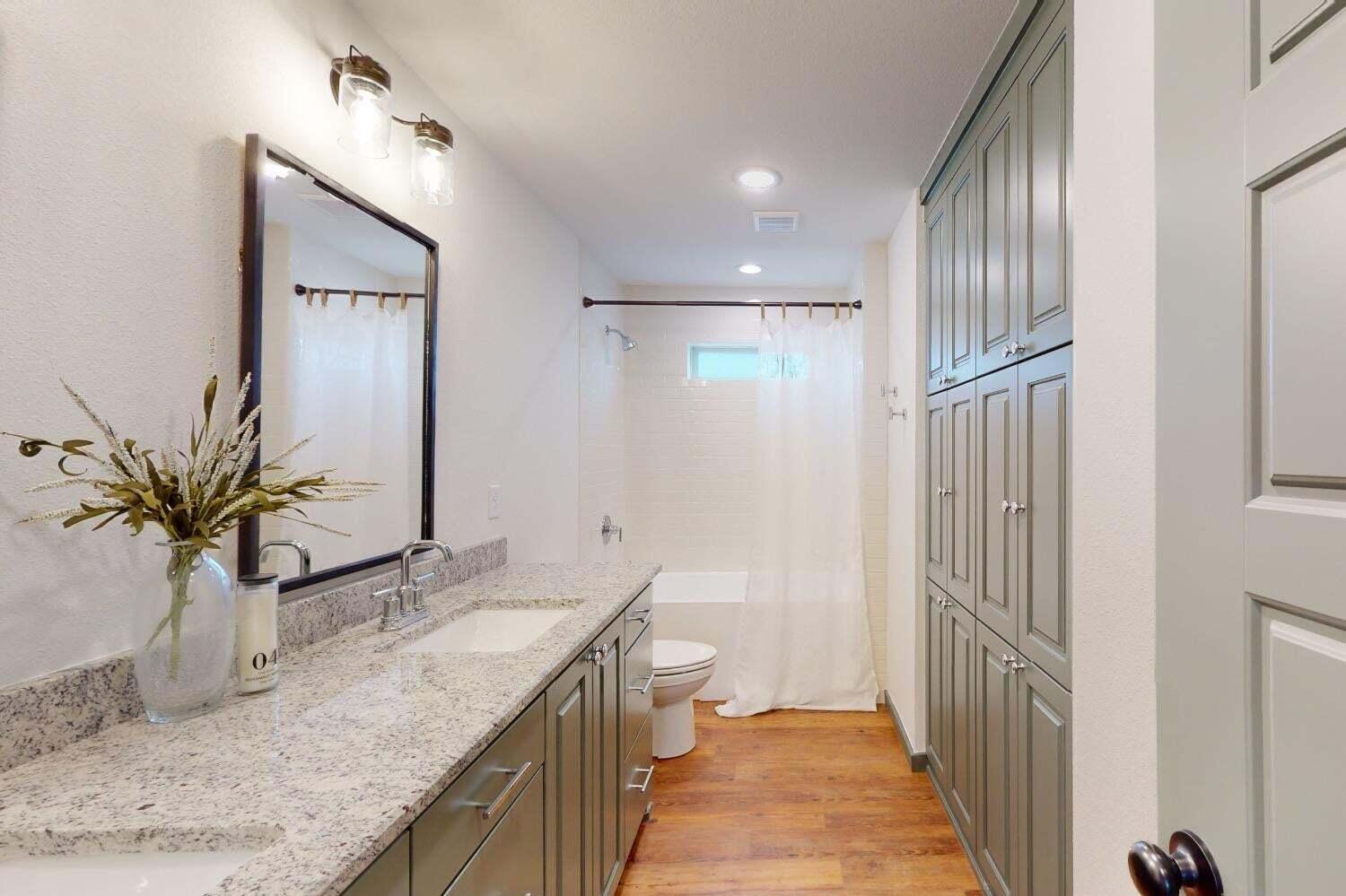 3617 128th Street Lubbock, TX 79423 - Photo 21 of 30 a bathroom with a granite countertop sink a large mirror and a shower