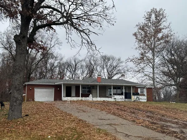 a front view of a house with a yard and trees