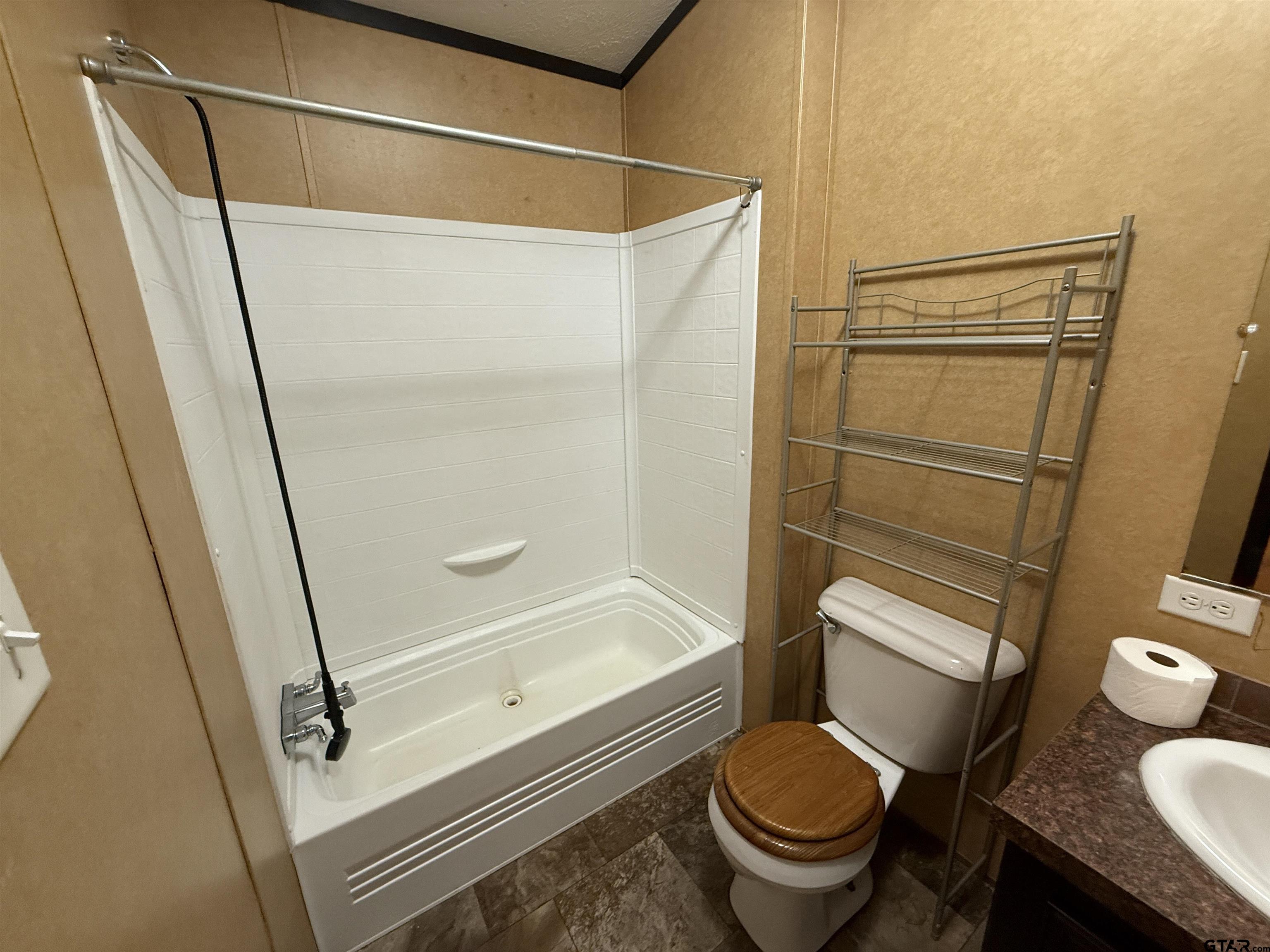 241 CR 2445 Rusk, TX 75785 - Photo 4 of 11 a bathroom with a granite countertop toilet and a shower