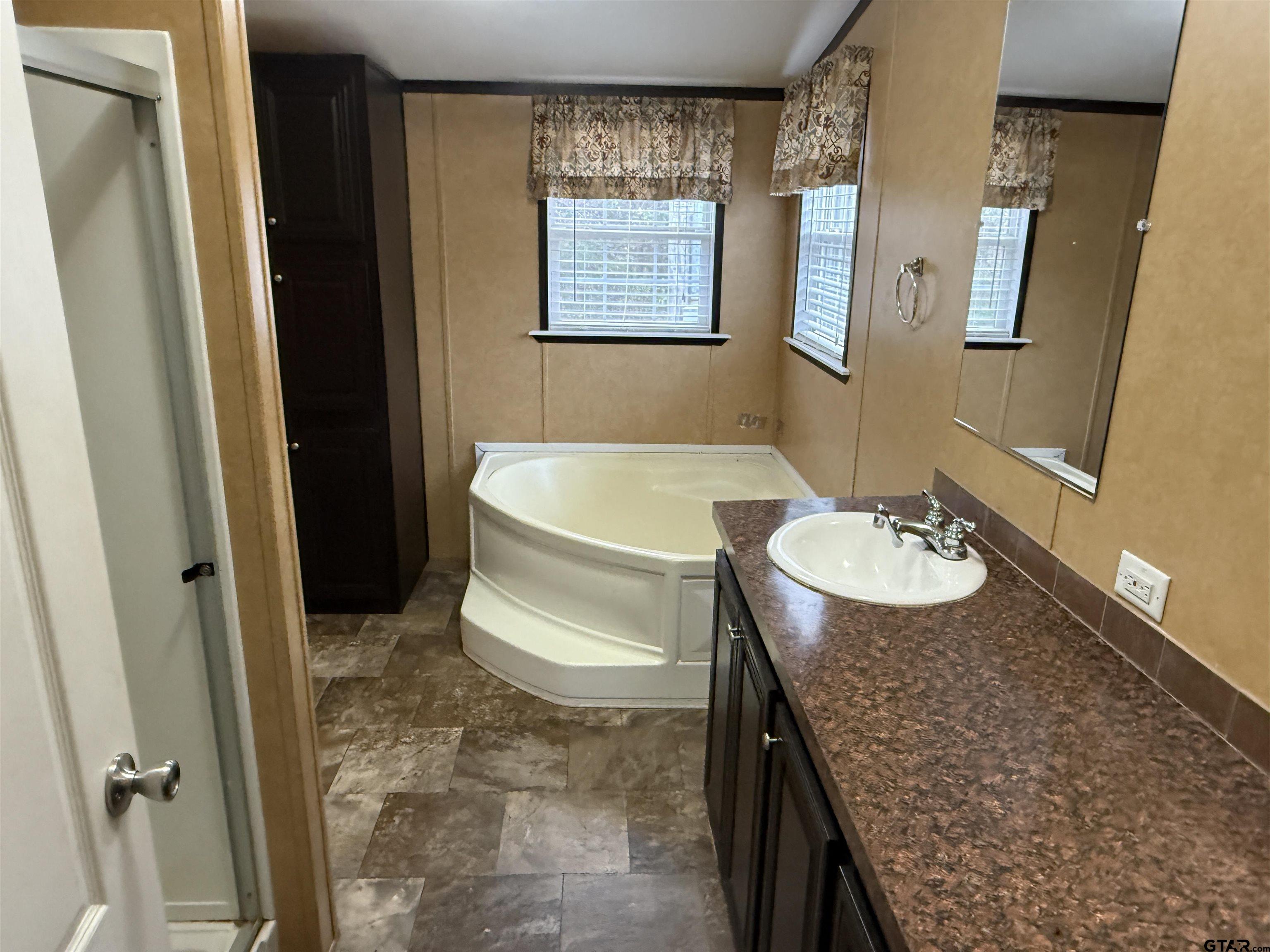241 CR 2445 Rusk, TX 75785 - Photo 9 of 11 a bathroom with a granite countertop sink and a mirror